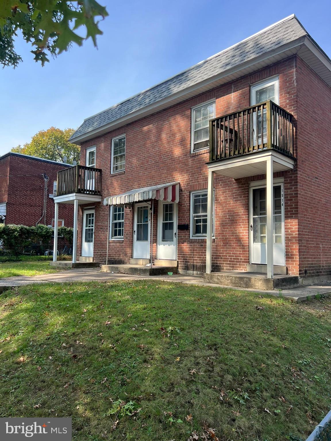 front view of a brick house with a yard