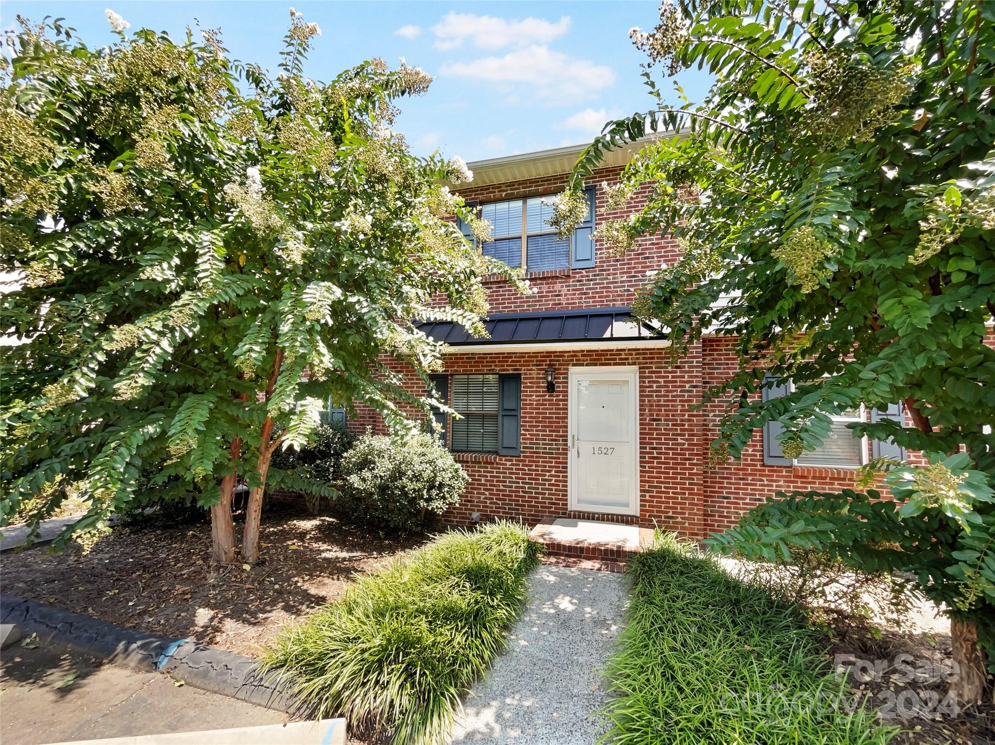 front view of a house with a tree