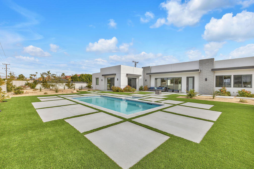 a view of a house with swimming pool and a yard