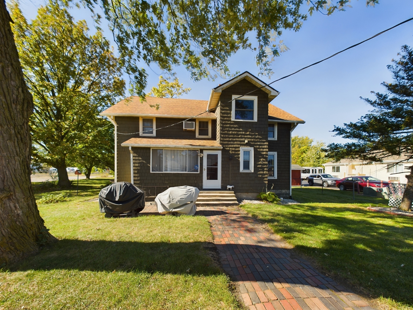 a front view of a house with a yard table and chairs