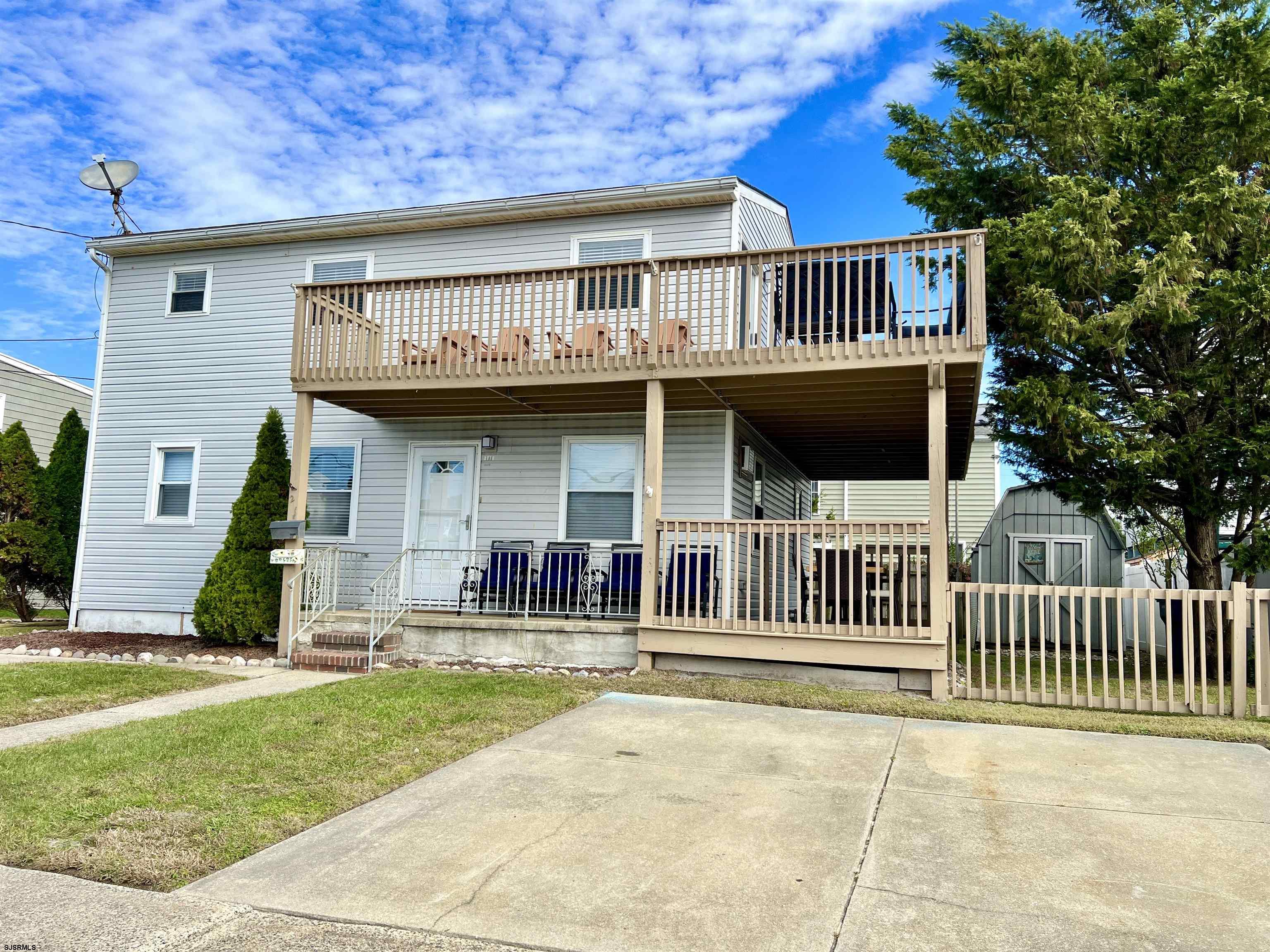 a view of a house with a deck and furniture