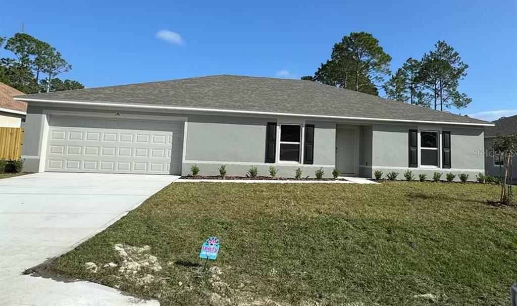 a view of a house with a yard and garage