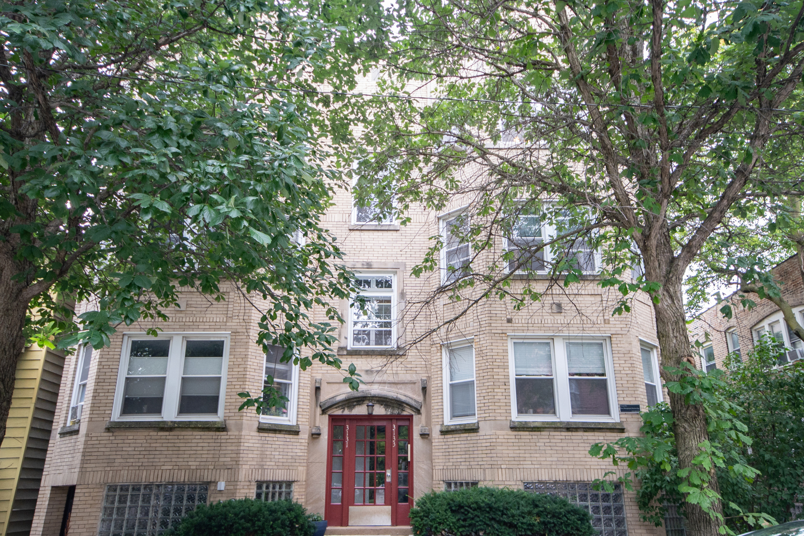 a front view of a house with a tree