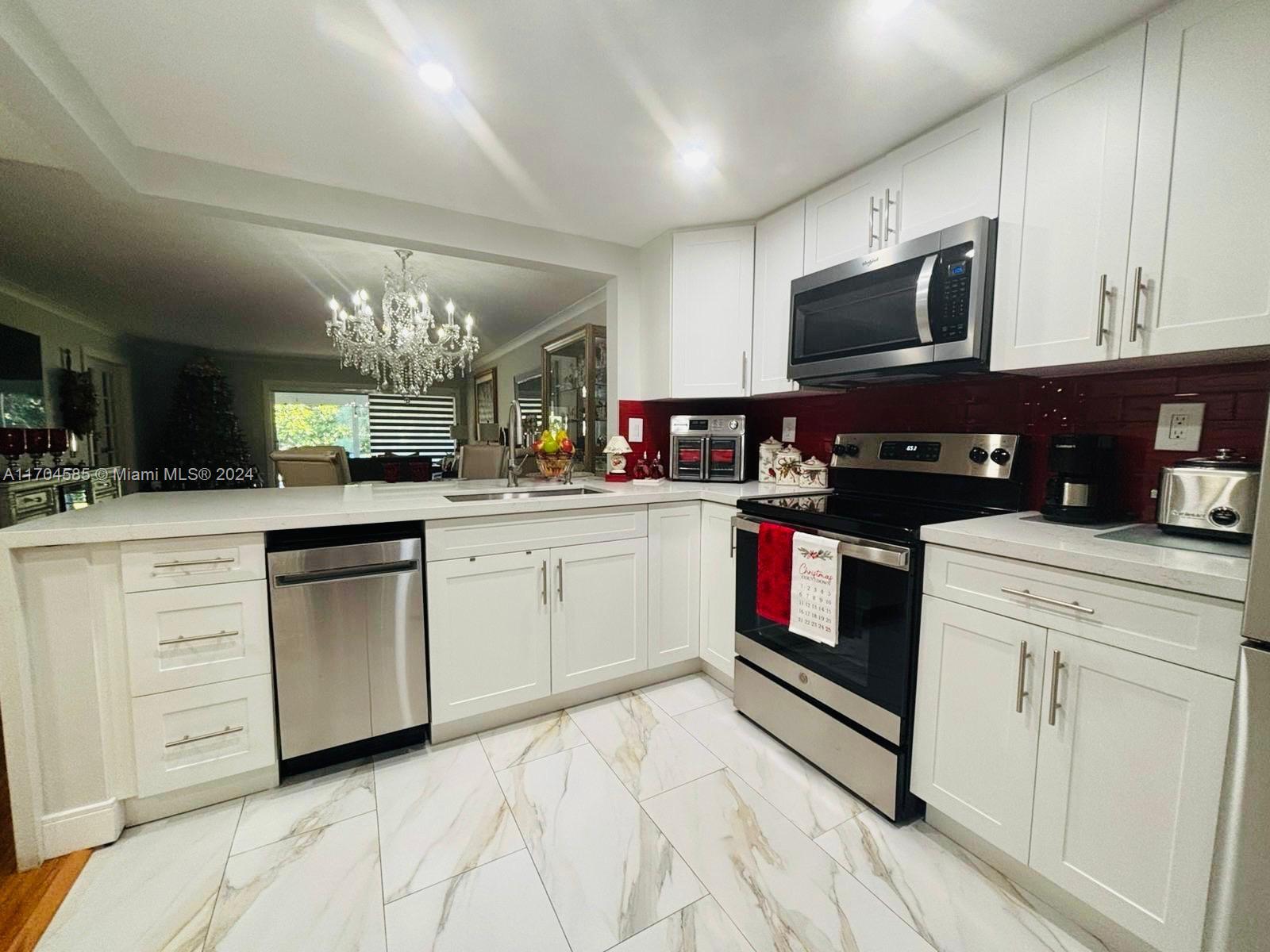 a kitchen with white cabinets stainless steel appliances and a counter top space