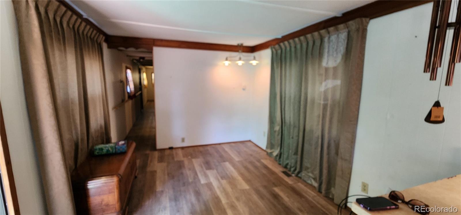 a view of a hallway with wooden floor and closet