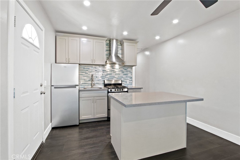 a kitchen with kitchen island white cabinets and stainless steel appliances