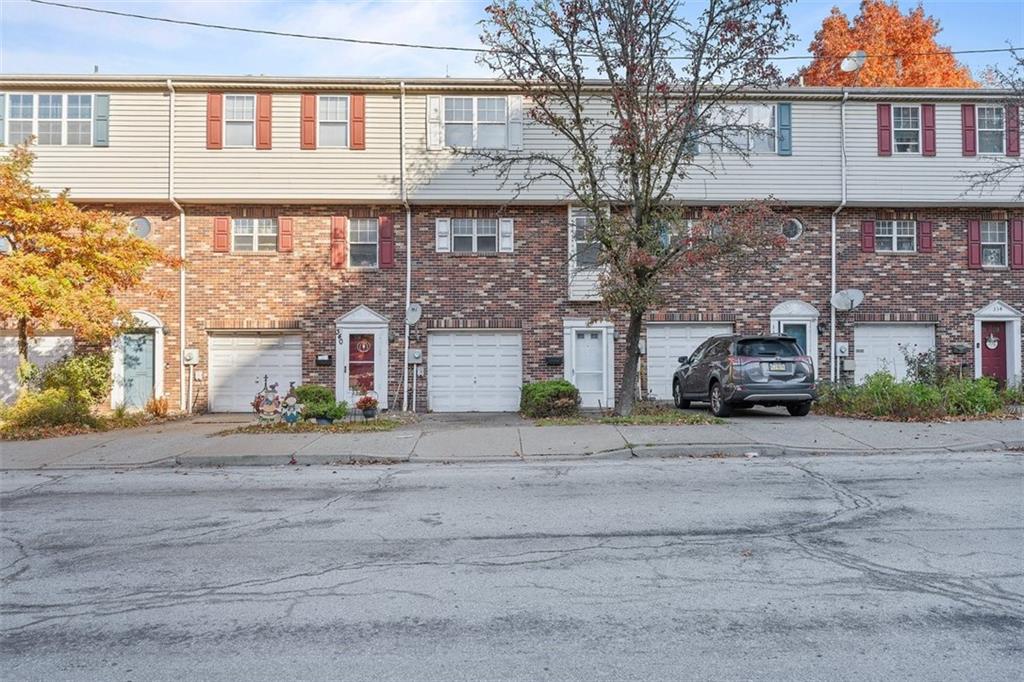 a front view of a house with a yard and a garage