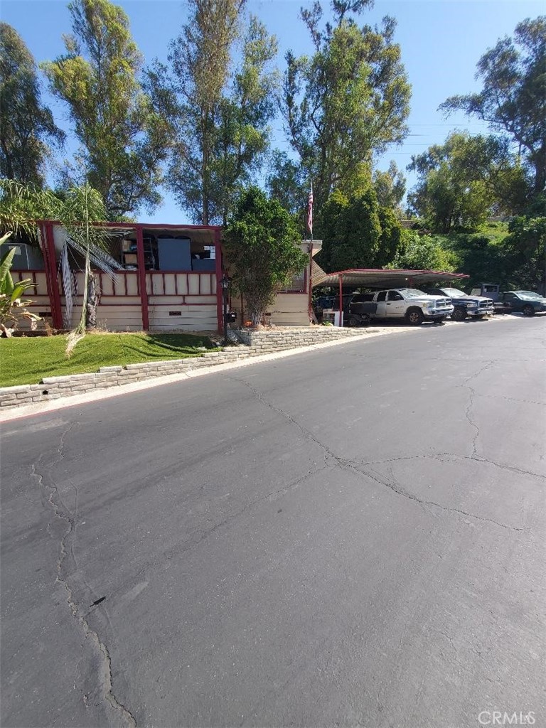 a view of road with house and trees in the background