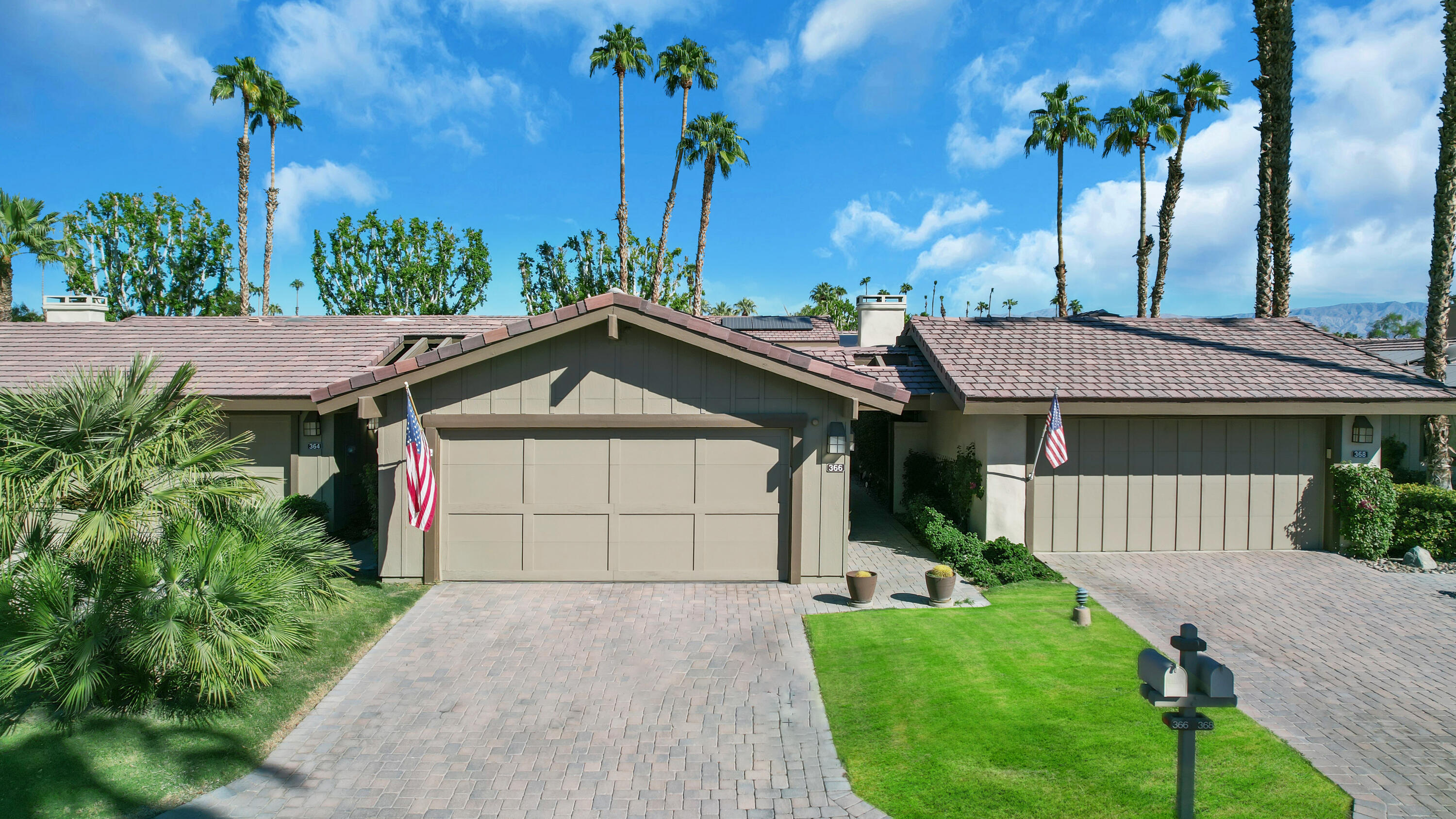 a front view of a house with a garden and yard