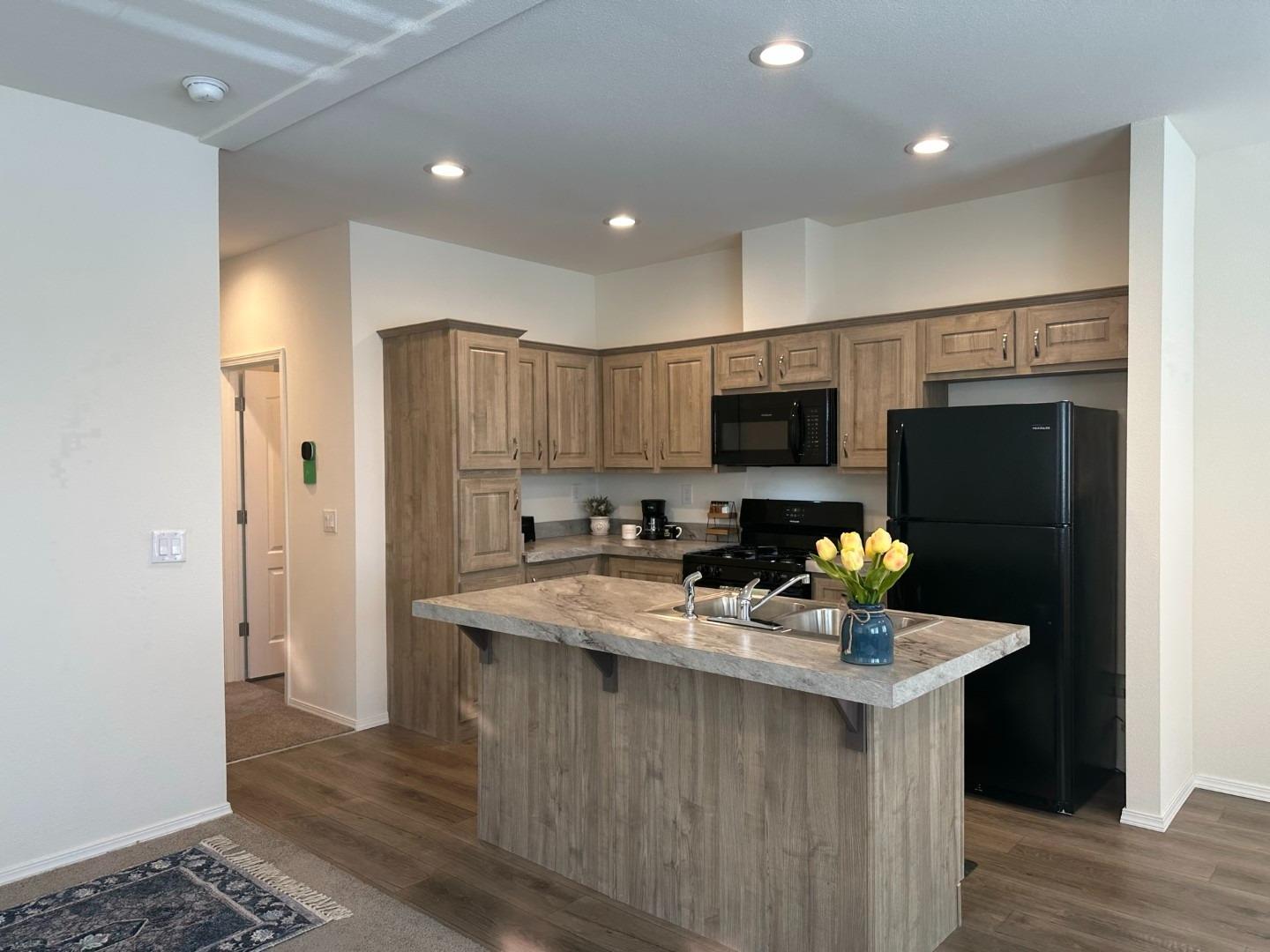 a kitchen with stainless steel appliances a refrigerator sink and microwave