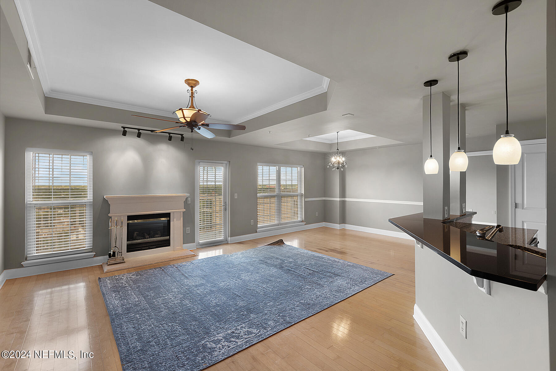 a view of a room with a ceiling fan fireplace and large window