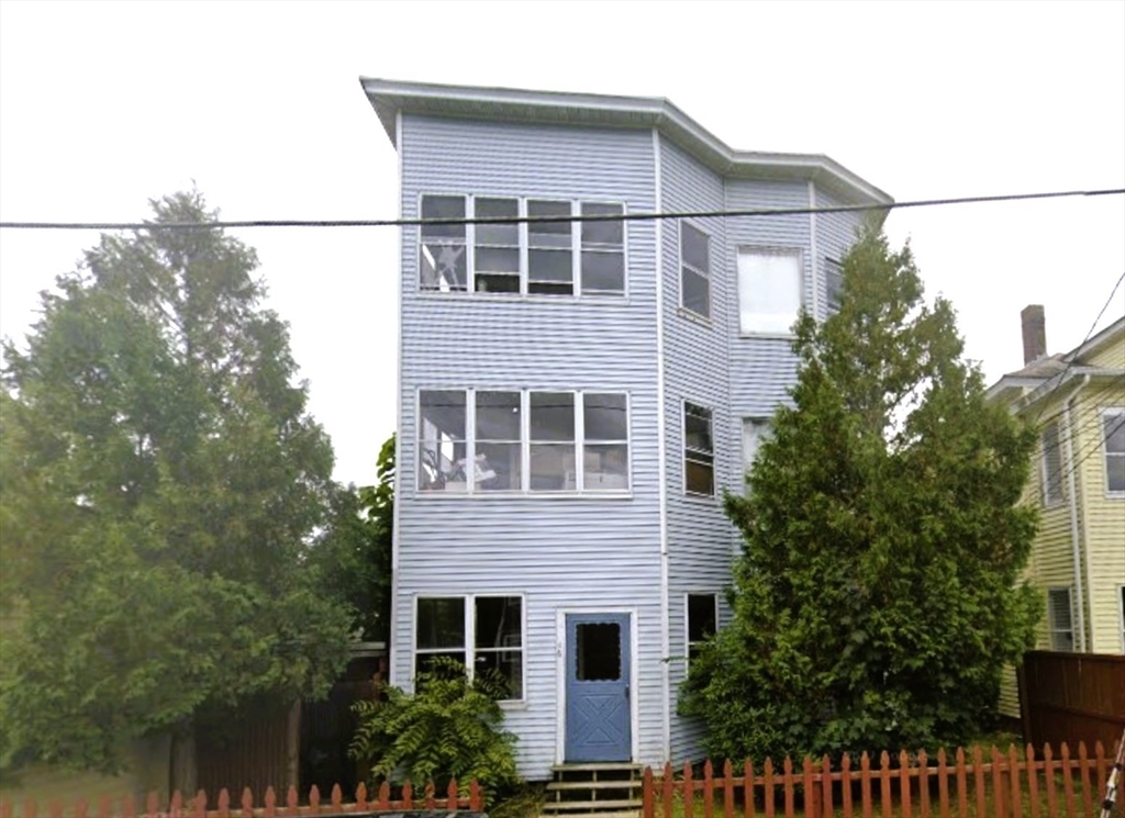 a front view of a house with plants