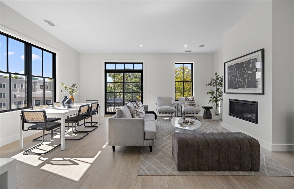 a living room with furniture large window and a fireplace