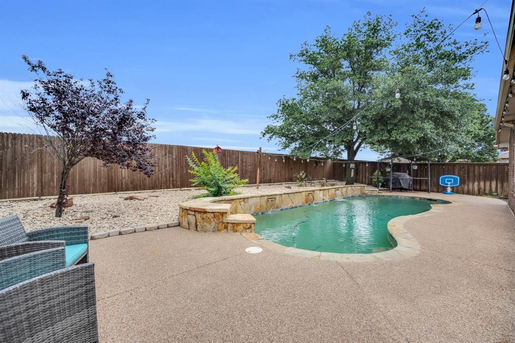 a view of a swimming pool with a patio and plants