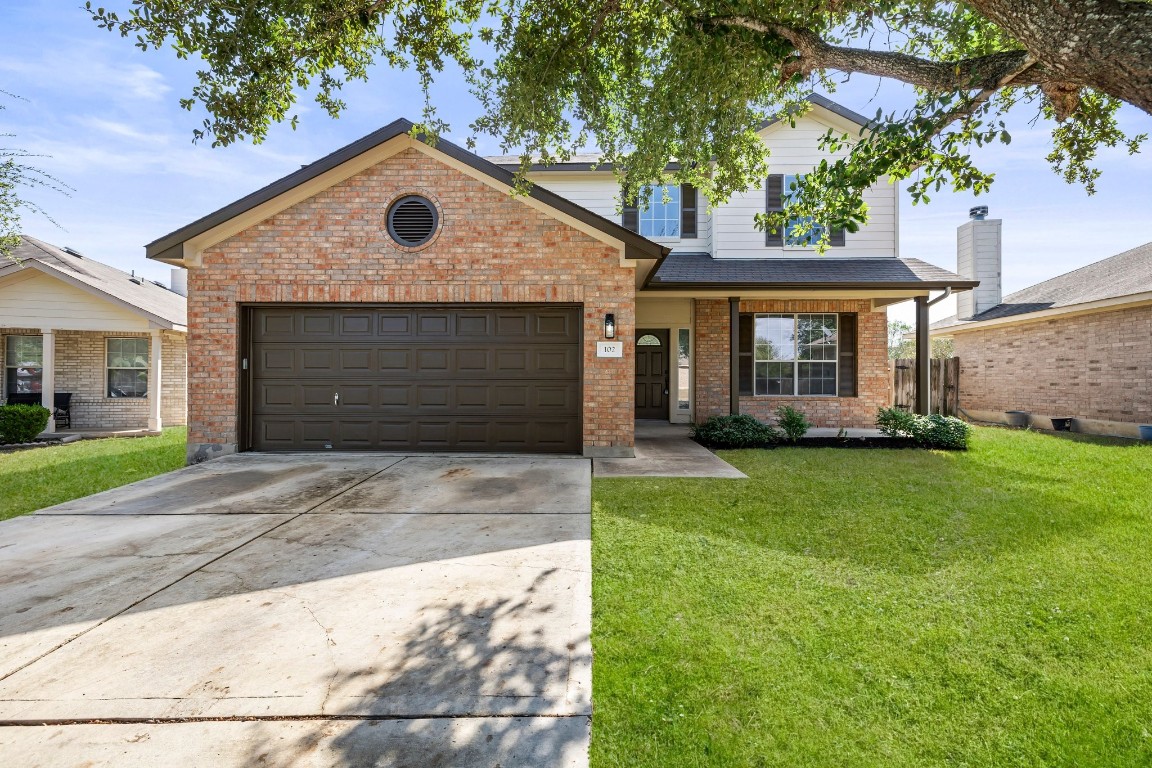 a front view of a house with a yard and garage