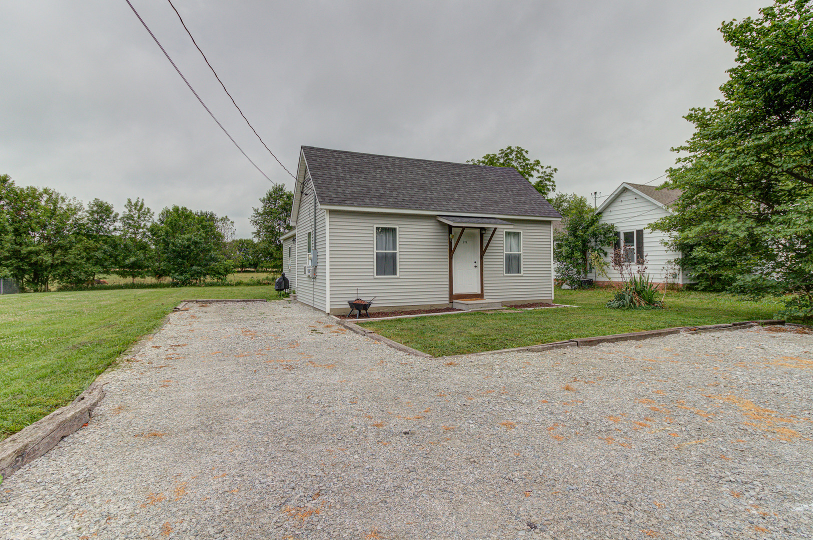 a view of a house with a yard and large tree