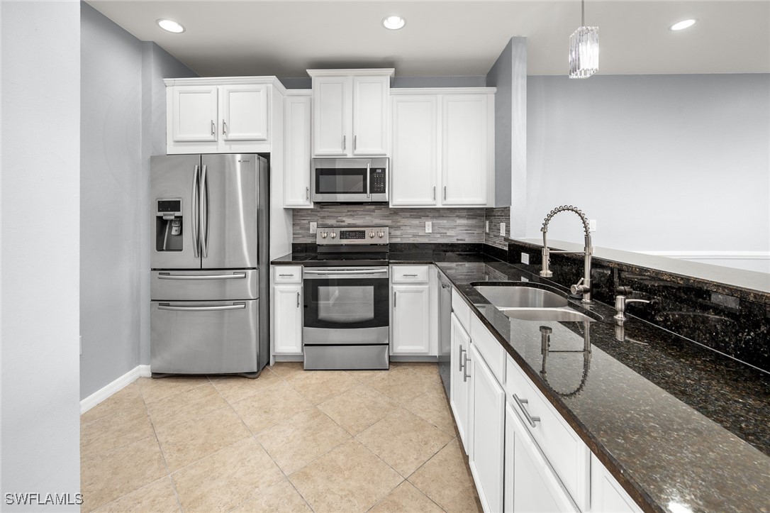 a kitchen with granite countertop a sink stainless steel appliances and cabinets