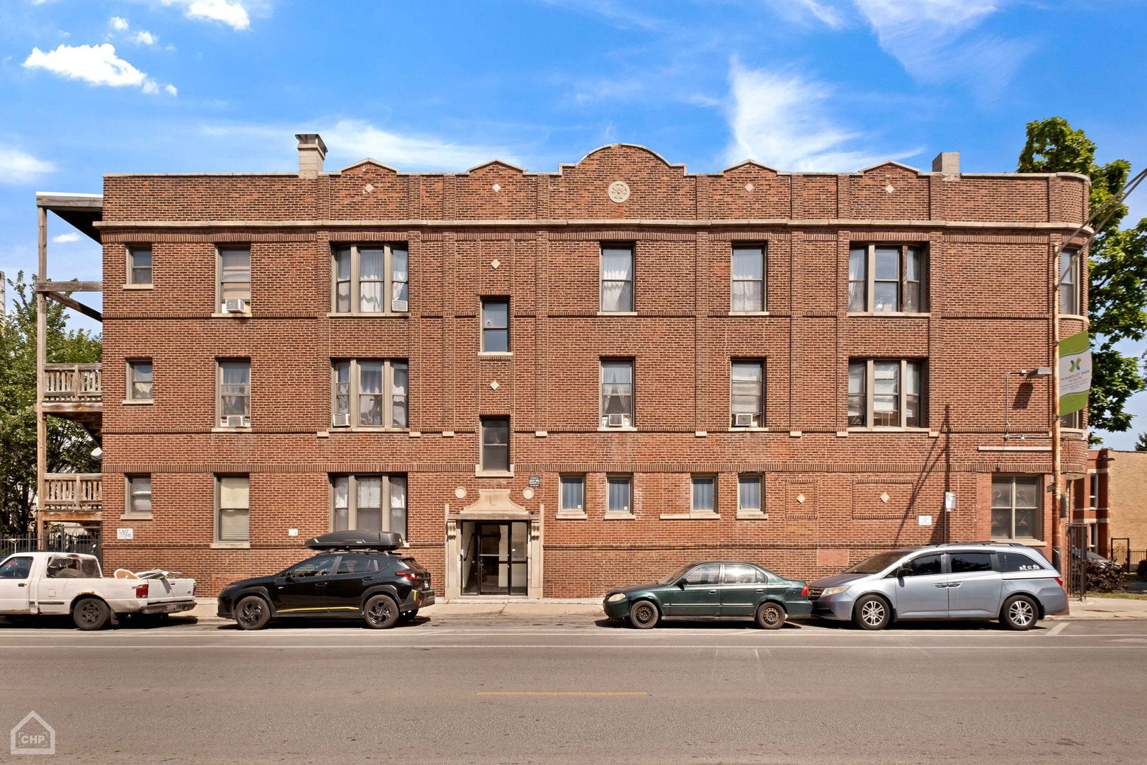 a front view of a residential apartment building with a yard