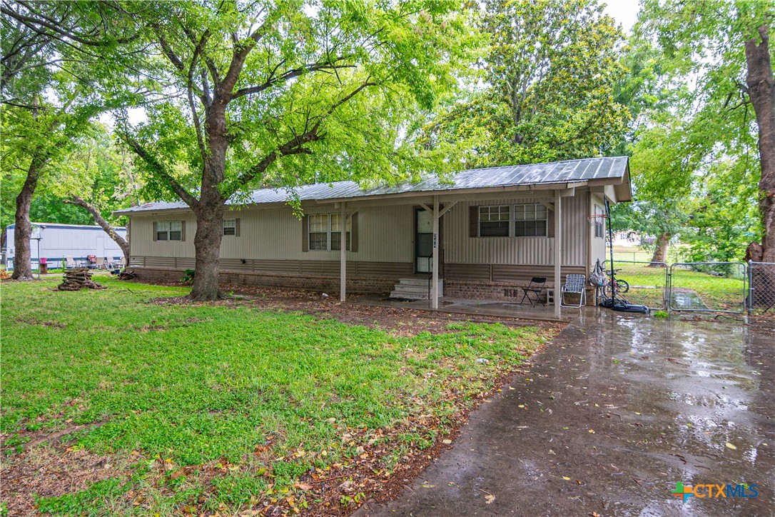 a view of a house with backyard and a tree