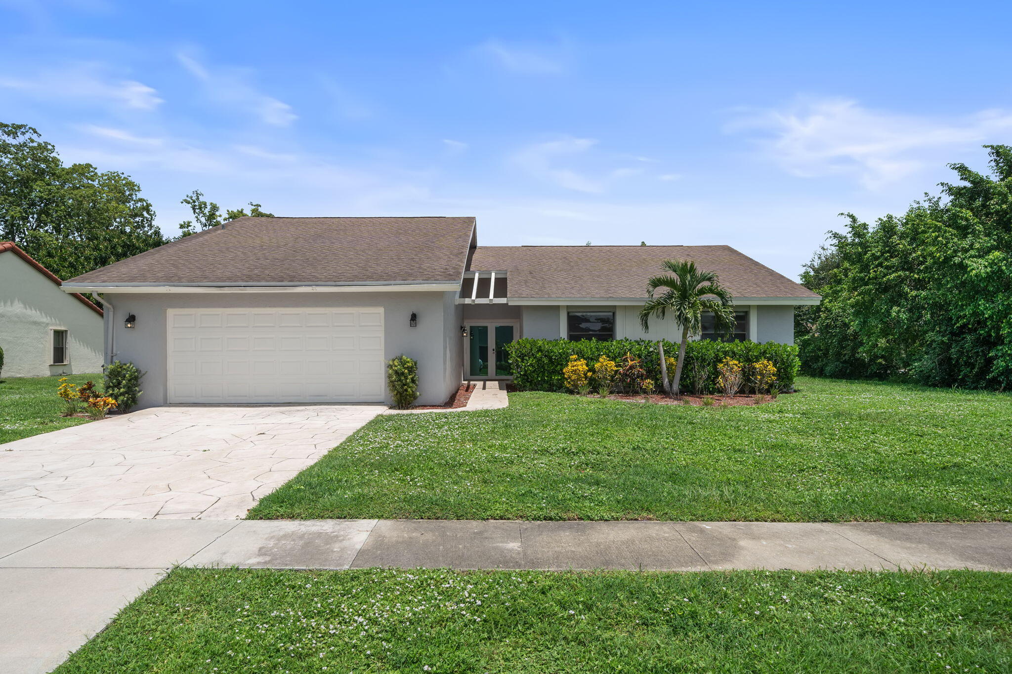 a front view of a house with a garden and yard