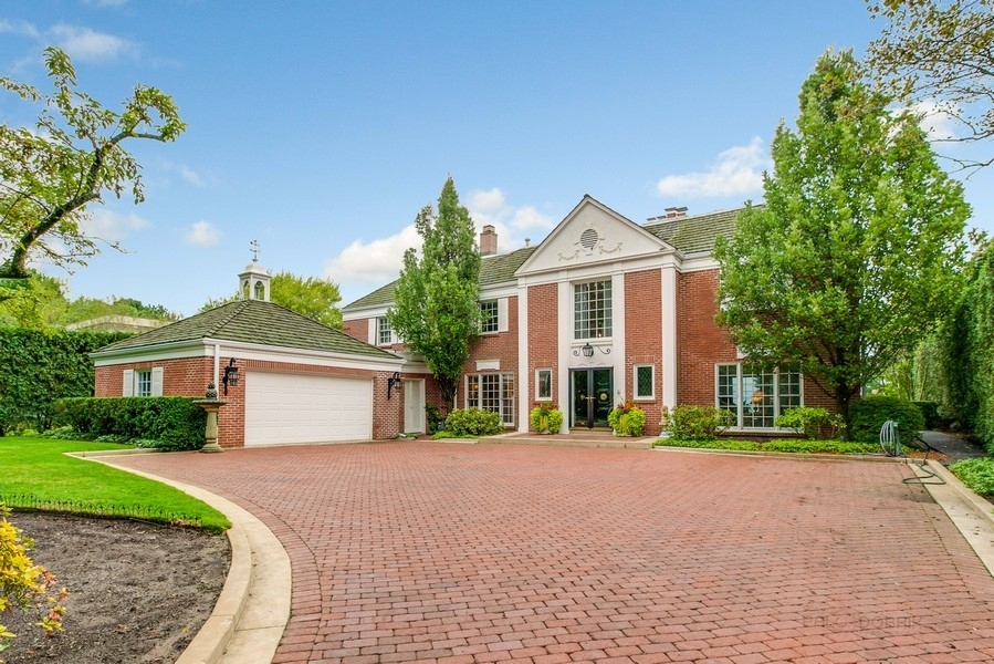 a front view of a house with a yard and trees