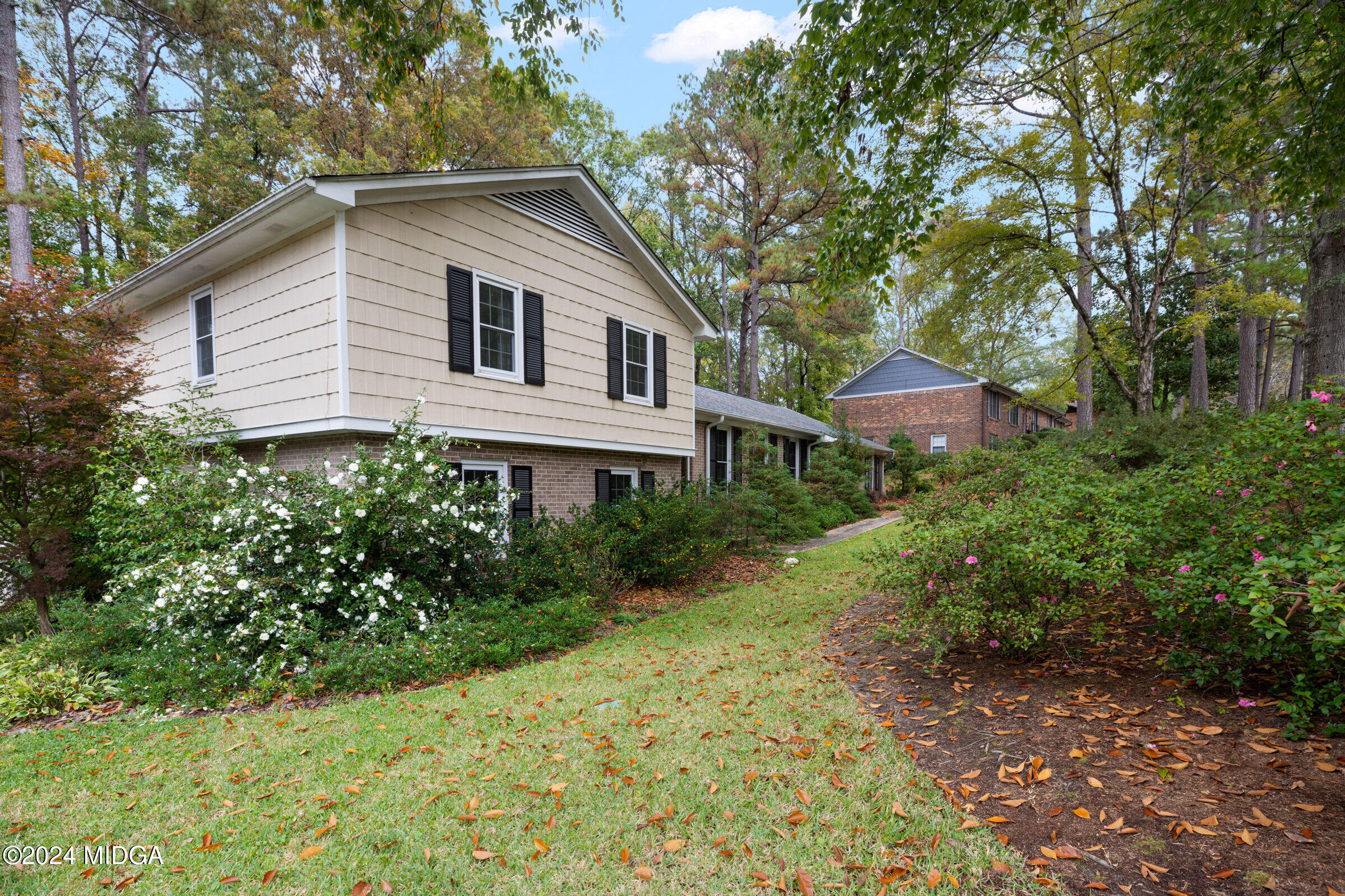 a view of a house with yard and sitting area