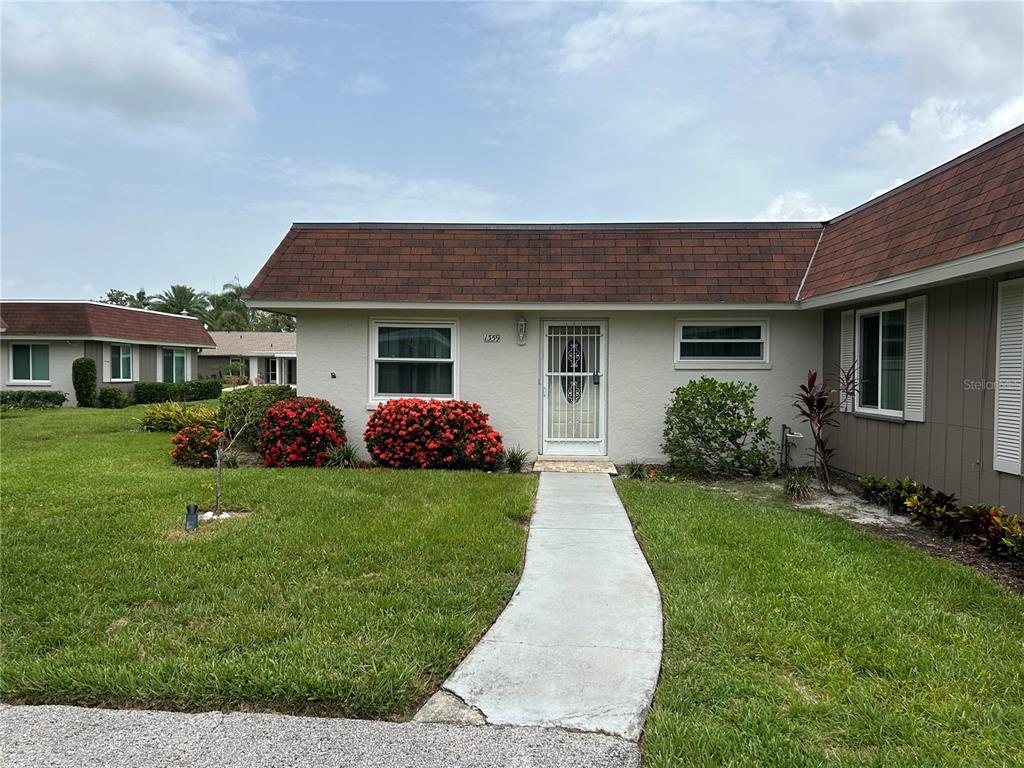 a front view of a house with a garden