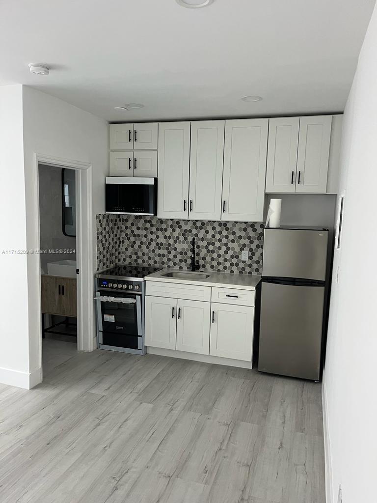 a kitchen with stainless steel appliances a refrigerator sink and cabinets