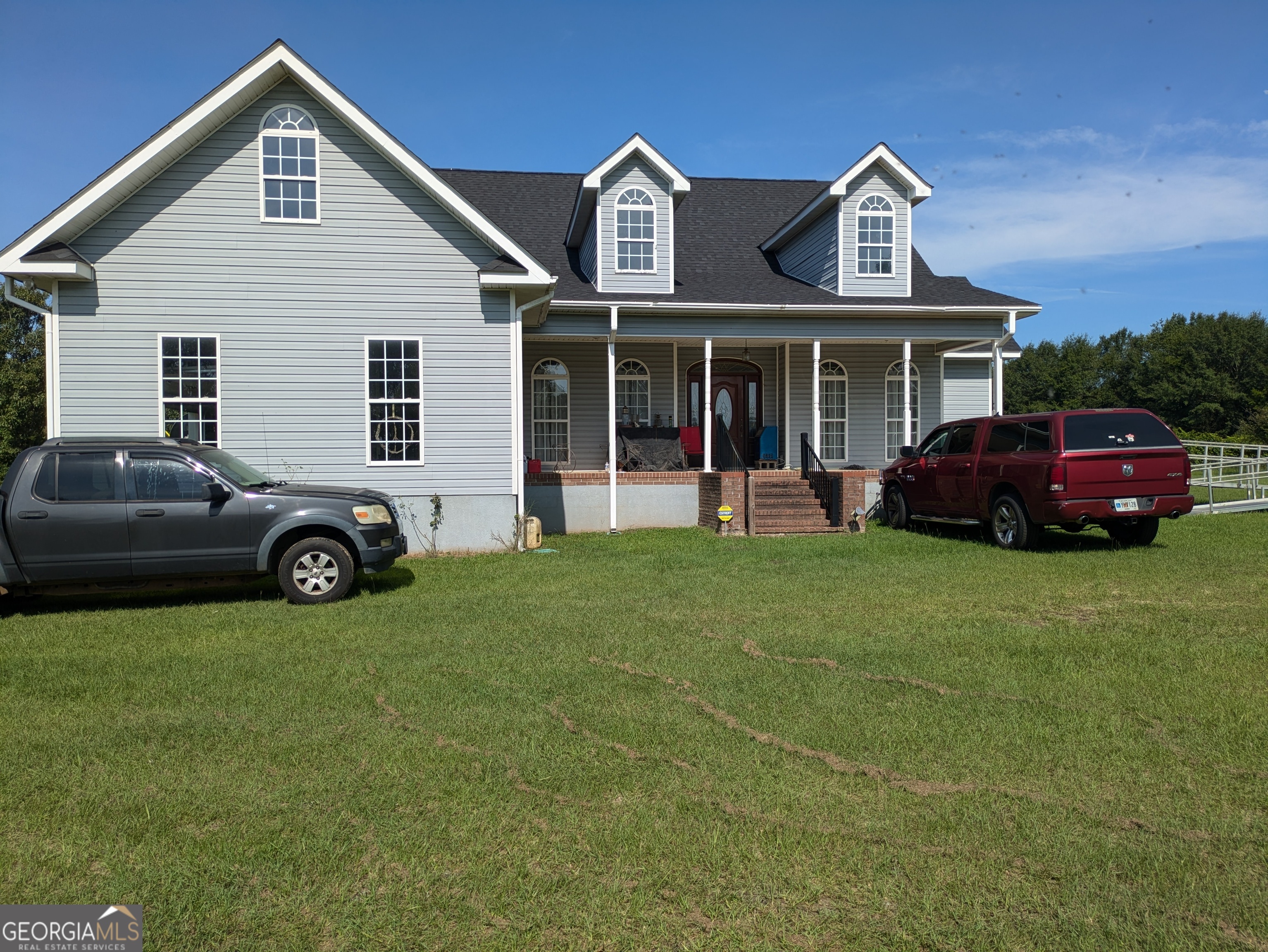 a front view of a house with a garden and parking space