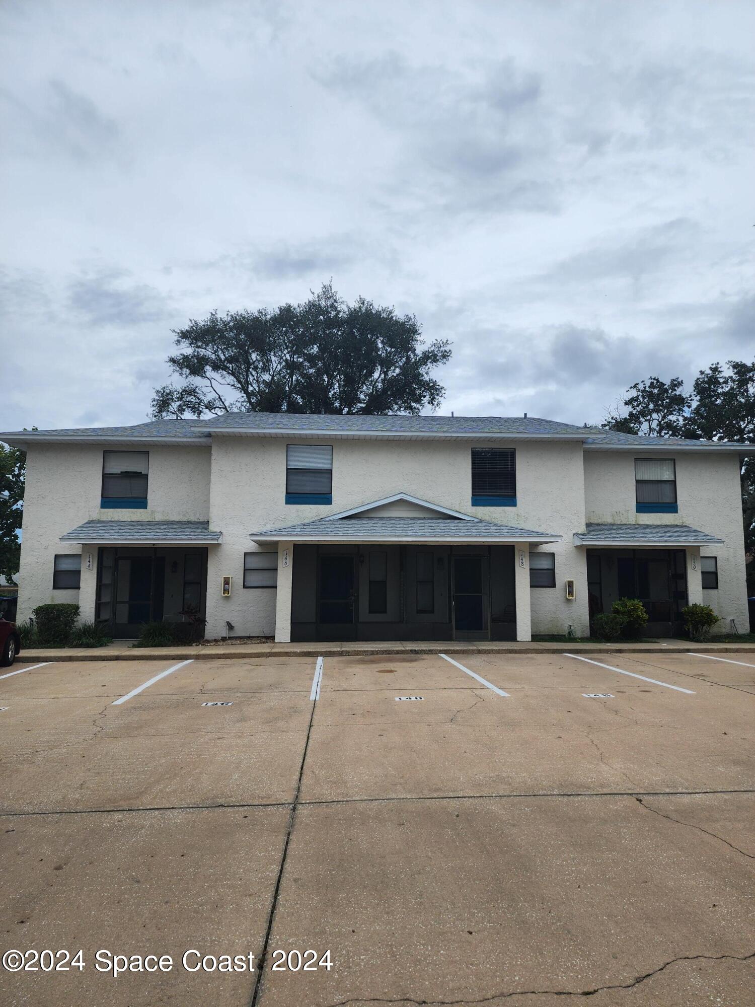 a view of house with yard and car parked