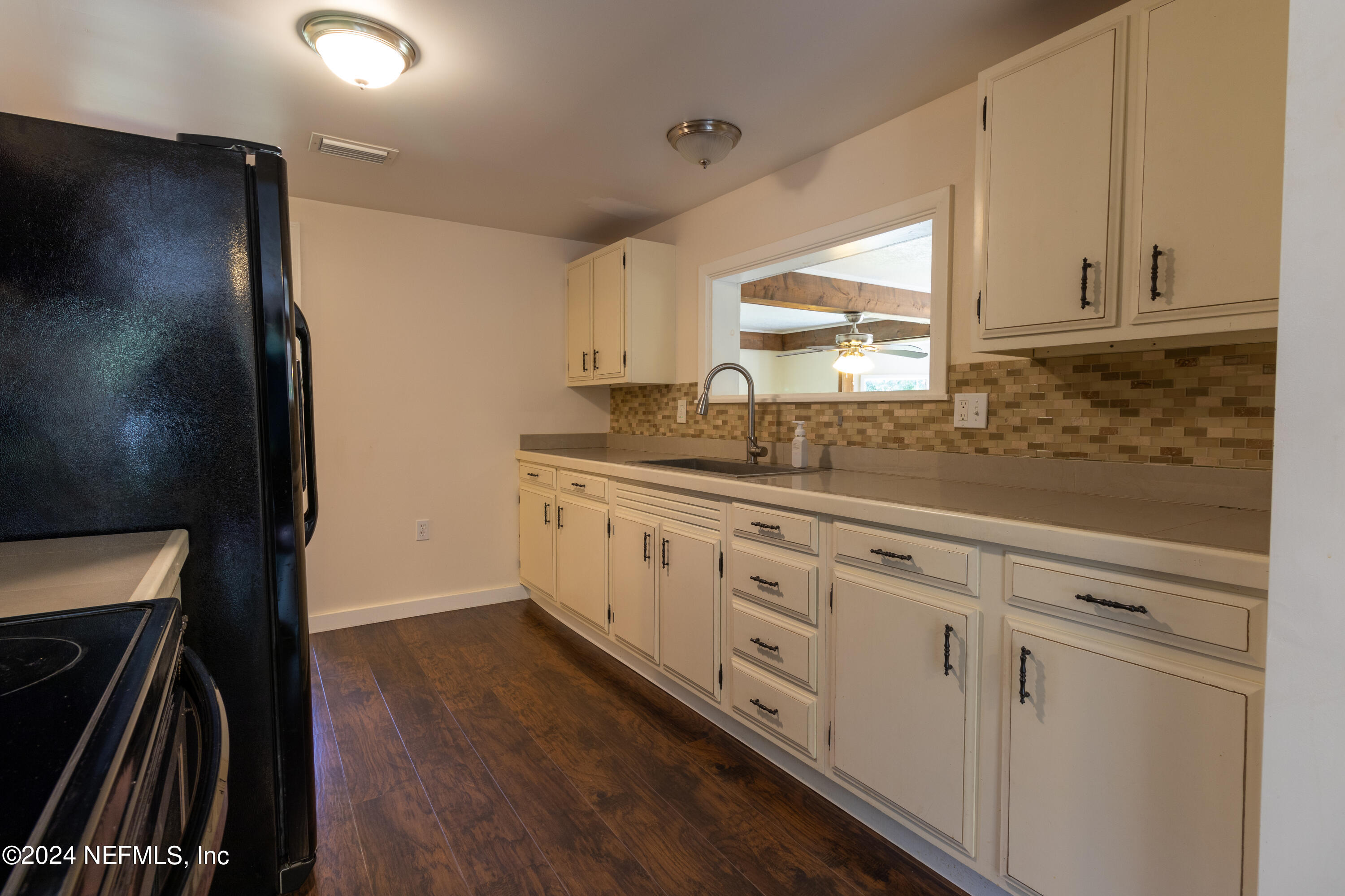 a kitchen with granite countertop white cabinets and white appliances