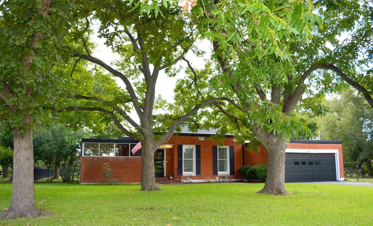 a front view of a house with a garden and yard