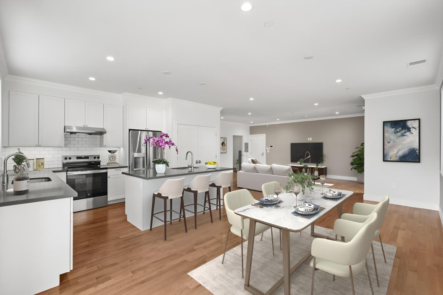 a living room with stainless steel appliances kitchen island granite countertop a stove a kitchen island a dining table and chairs with wooden floor