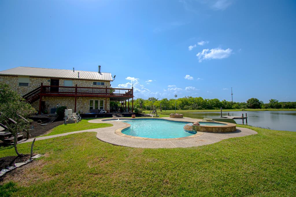 a view of a house with swimming pool and a yard