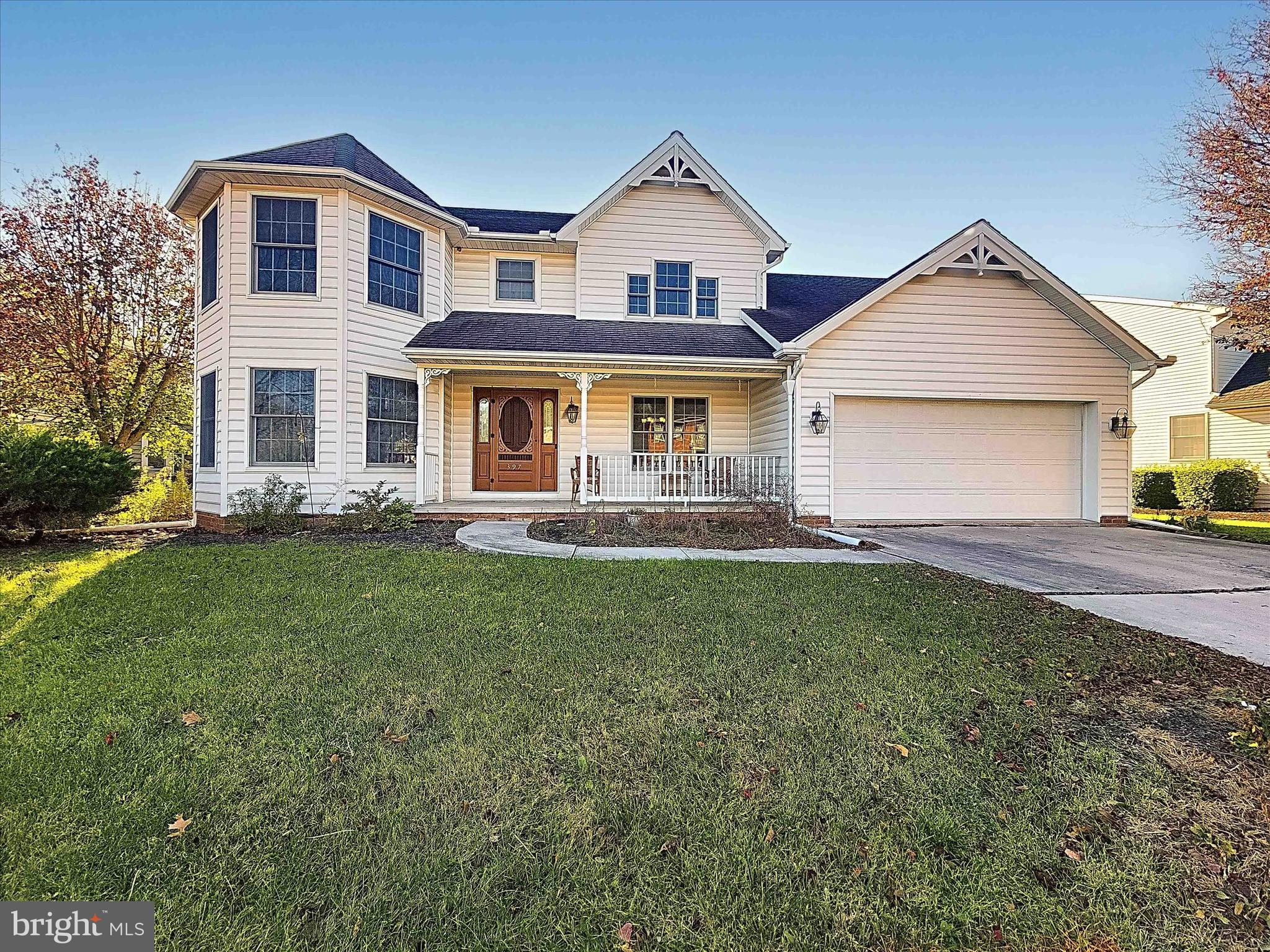 a front view of a house with a yard and green space