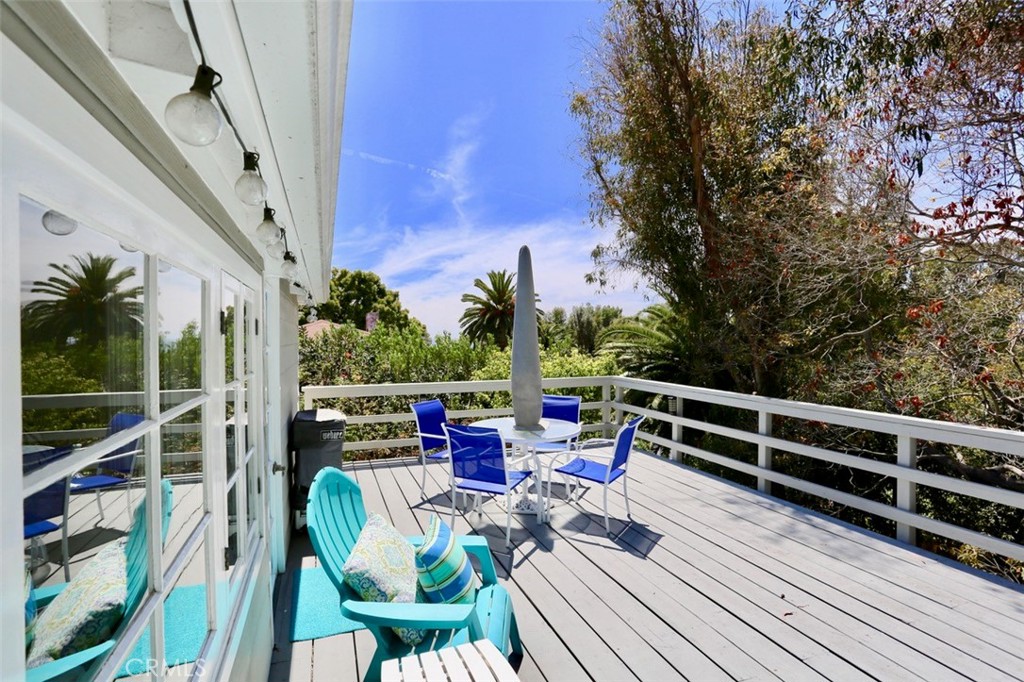 a view of deck with seating space and trees in the background