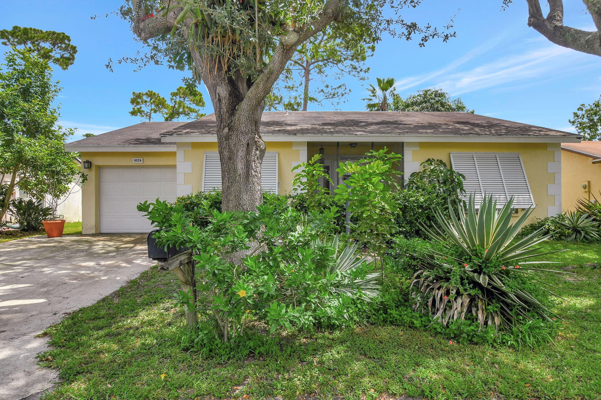 a front view of a house with a yard and potted plants