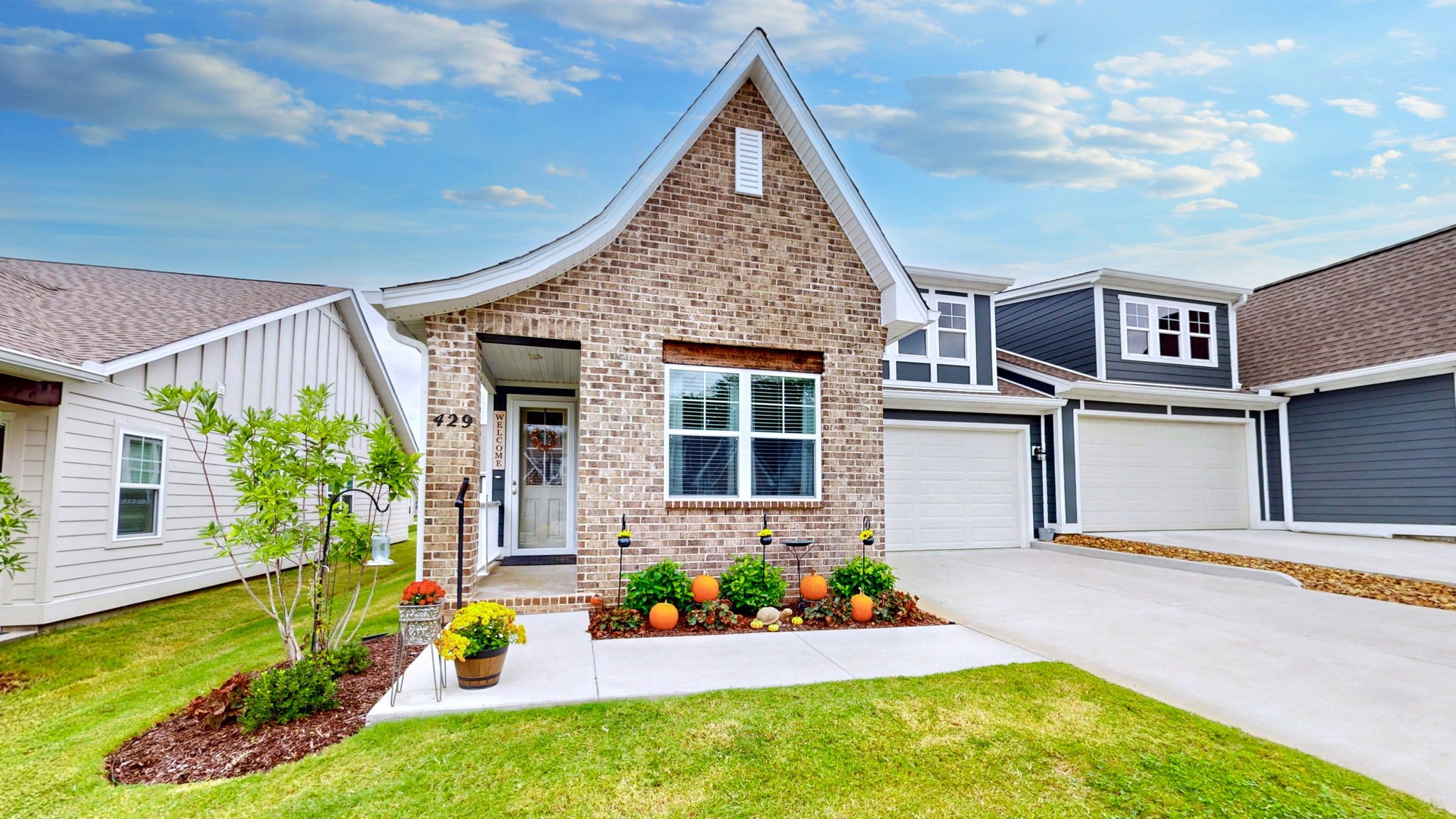 a front view of a house with a yard and potted plants