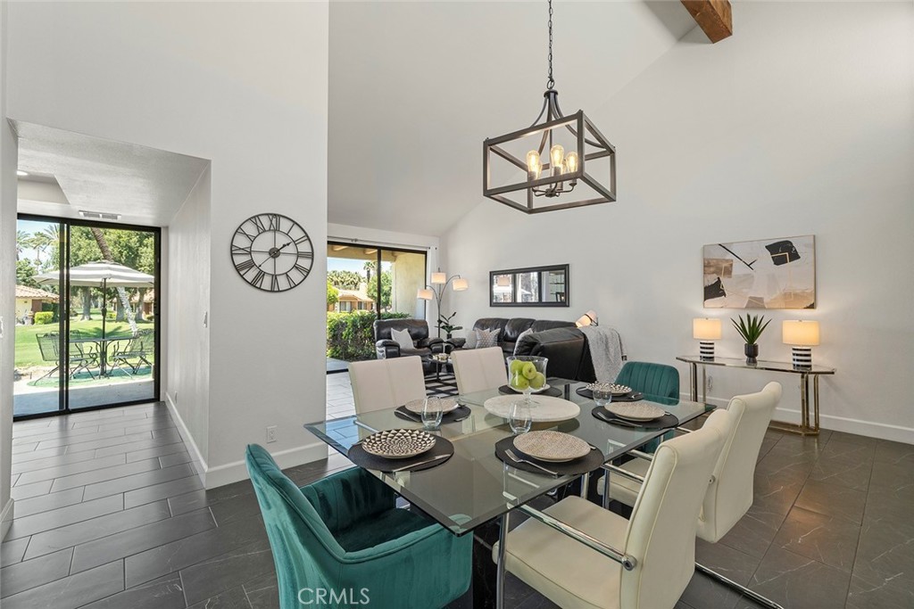 a dining room with wooden floor a chandelier a wooden table and chairs