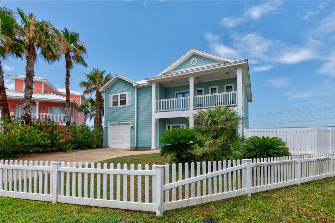 a view of a house with a small yard and wooden fence