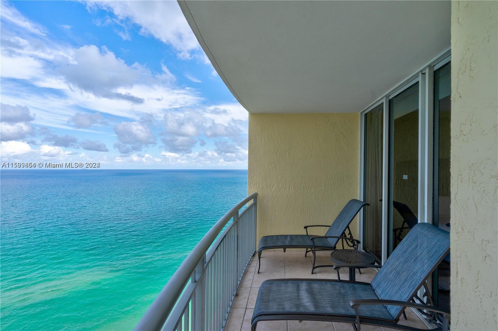 a view of a balcony with chair and wooden floor