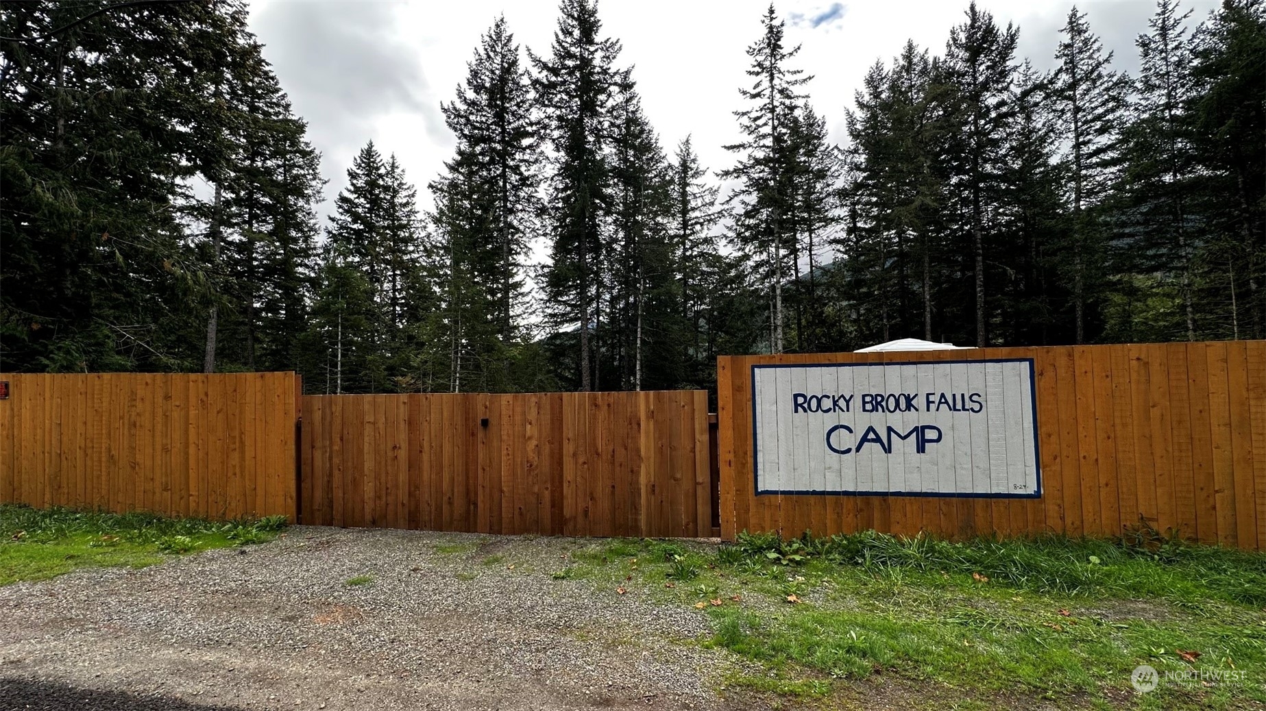 a sign that is sitting in front of a wooden fence