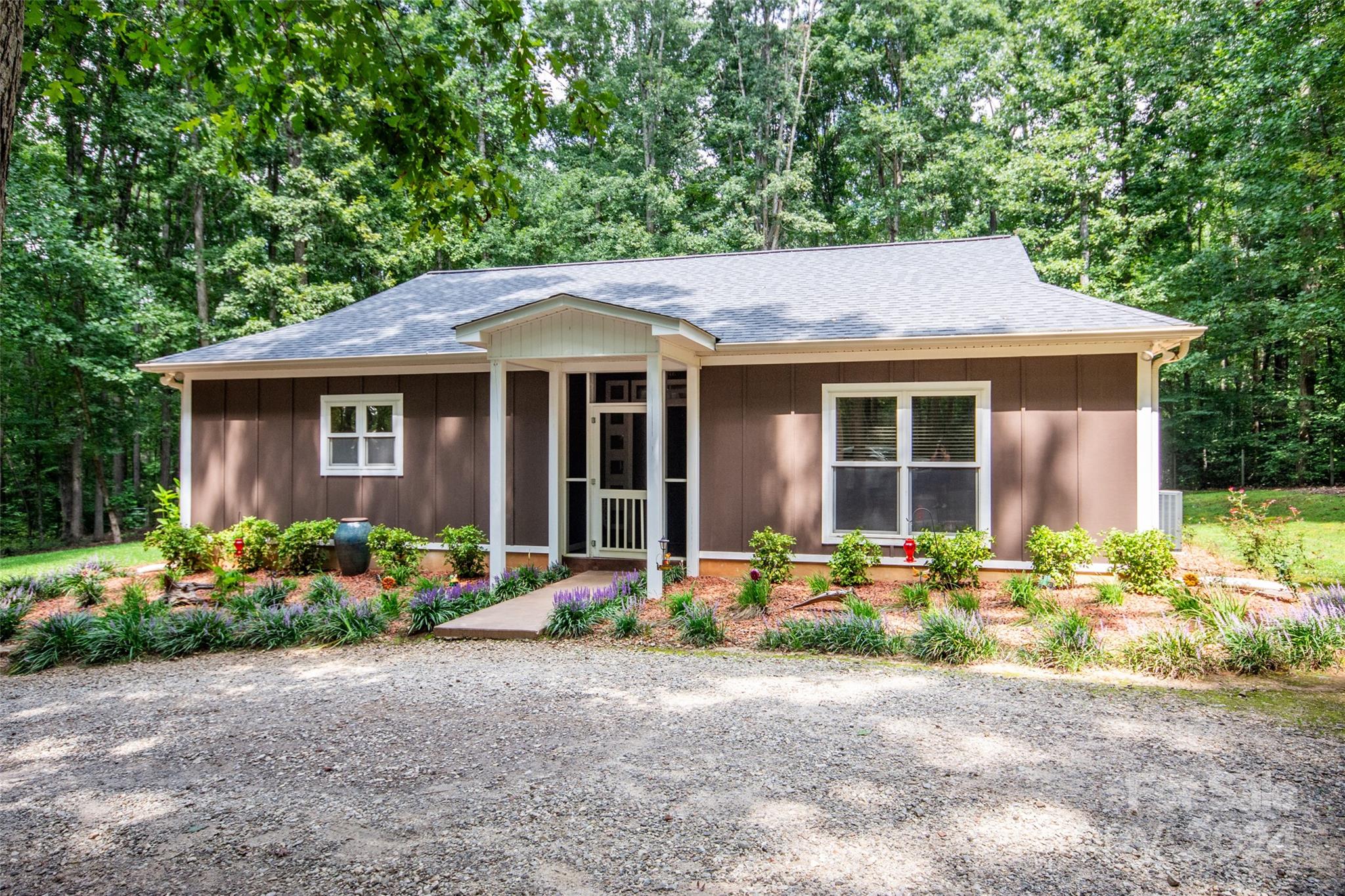 a front view of a house with a garden and plants