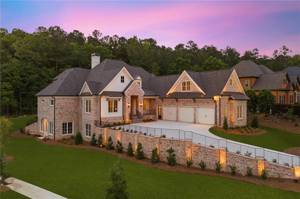 a front view of a house with a yard and lake view