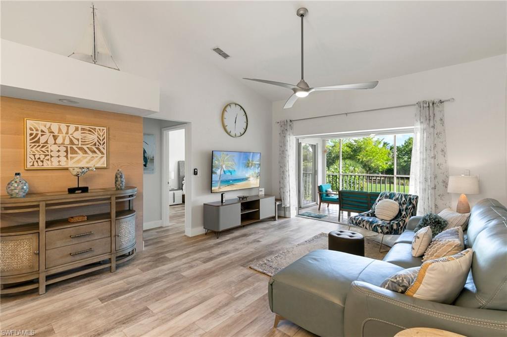 a living room with furniture flat screen tv and a large window