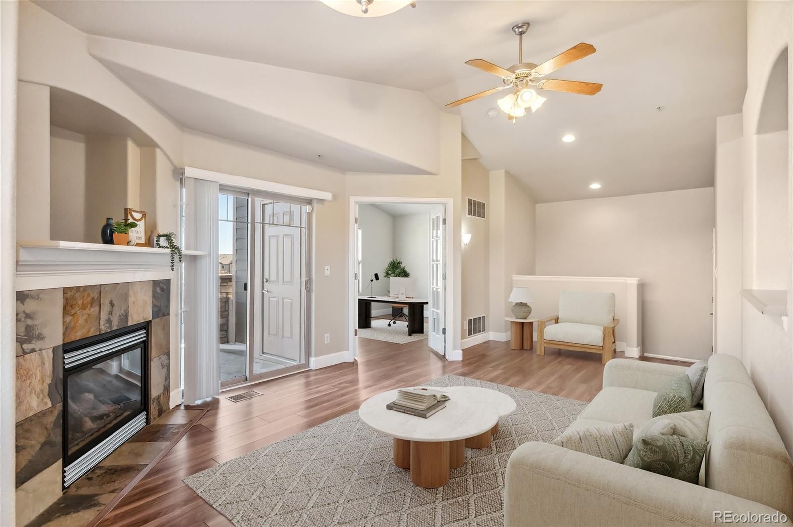 a living room with furniture and a fireplace with wooden floor