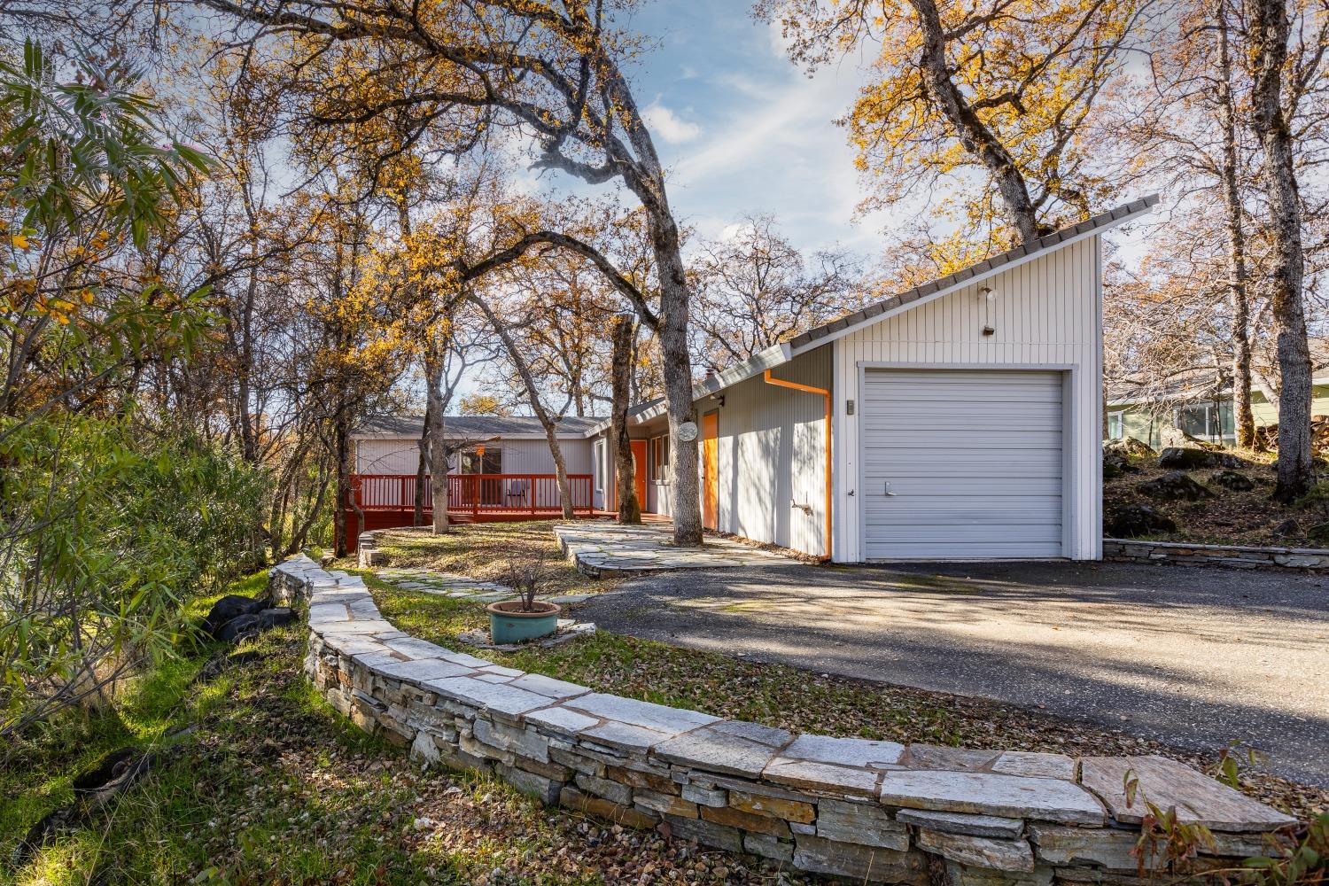 a view of a house with a yard tree and wooden fence