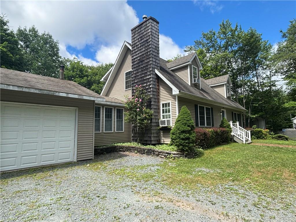 View of property exterior featuring a garage and a yard