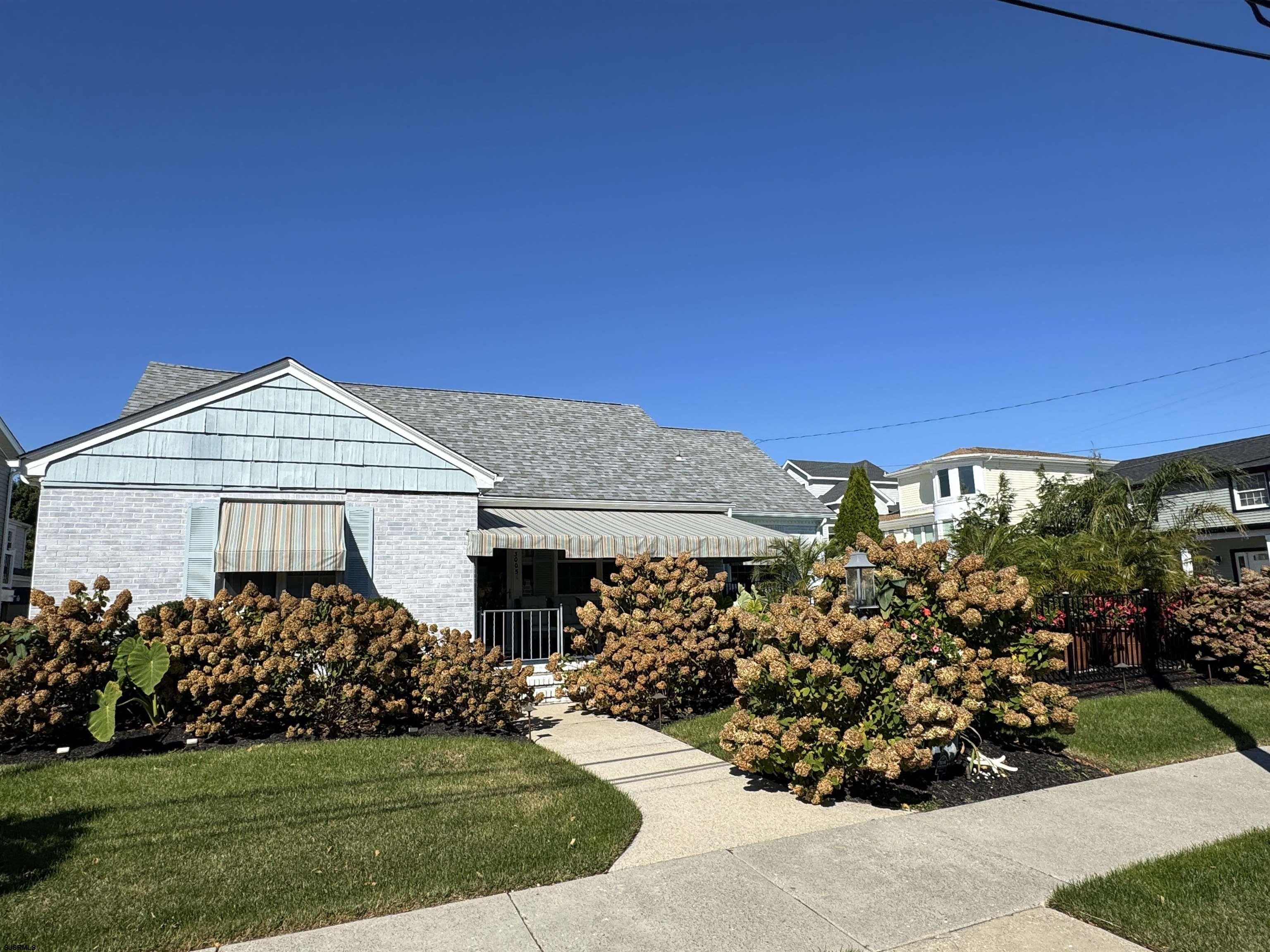 a view of a house with a big yard and potted plants