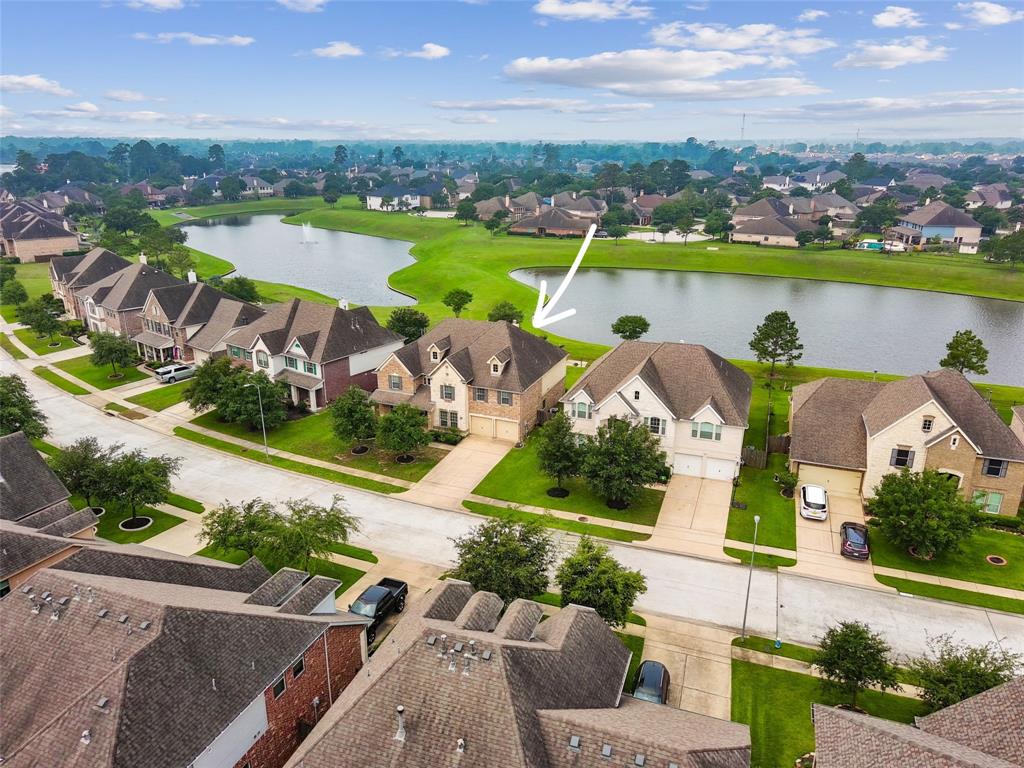 an aerial view of a house with a garden and lake view